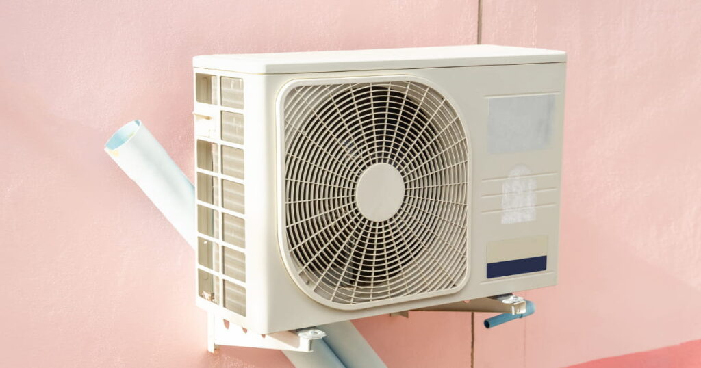 Pompe à chaleur de couleur blanche fixée sur un mur rose